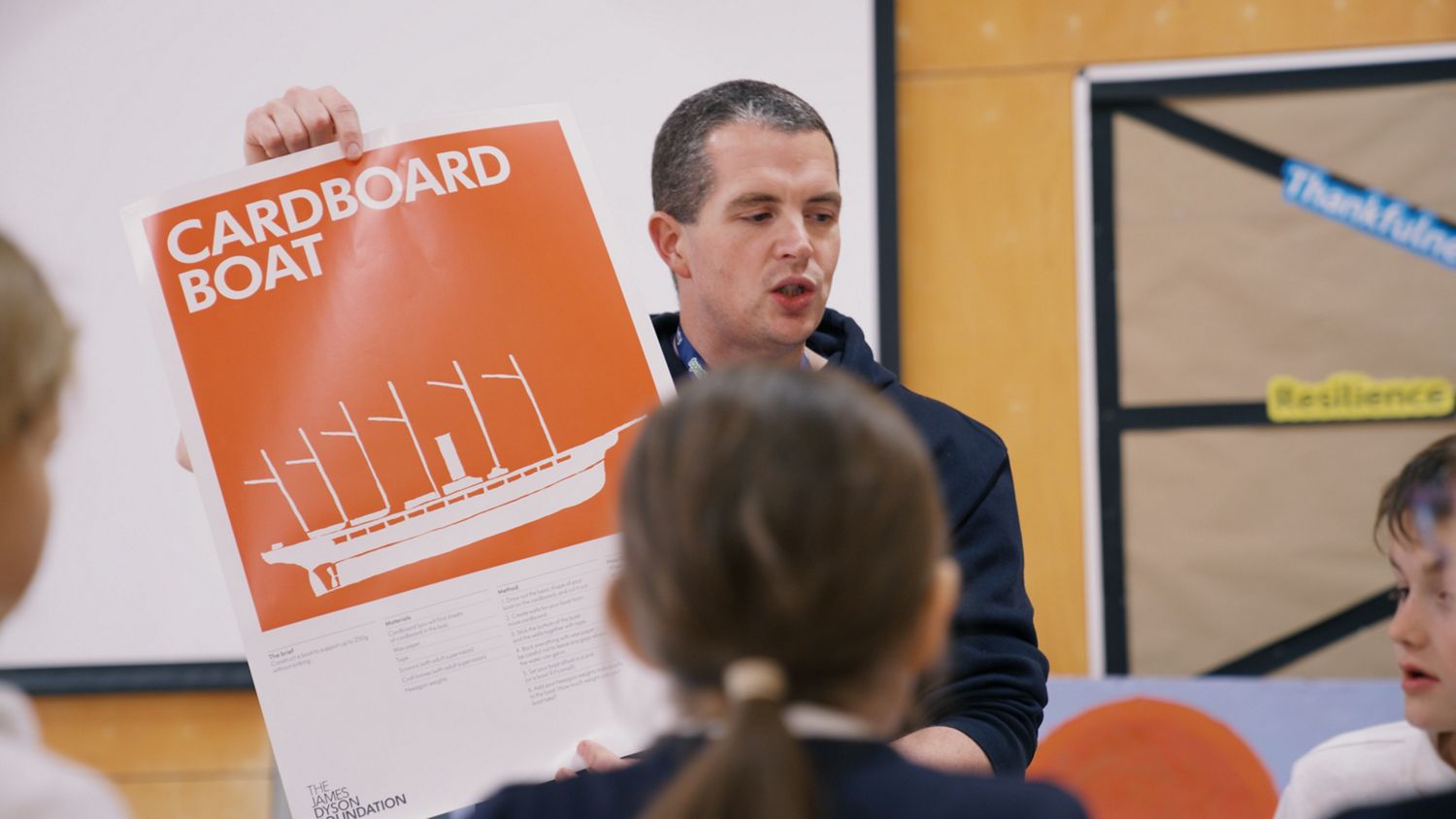 Teacher holding up JDF STEAM Week poster